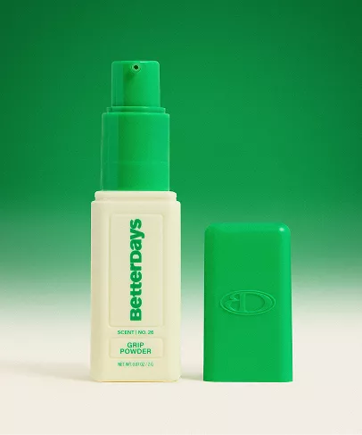 BetterDays Grip Powder bottle with a green pump and white body, shown next to its green cap on a green gradient background.